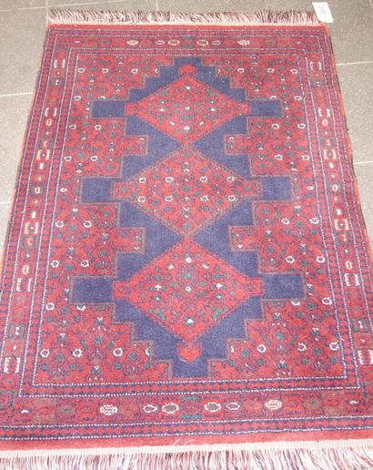 160- Tapis fait main sur fond rouge à décor...