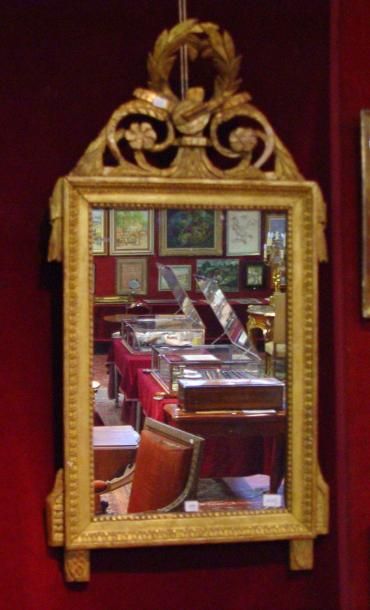 Un miroir, cadre en bois sculpté et doré....
