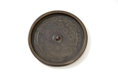 Bronze mirror with moulded decoration of...