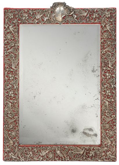Silver-framed table mirror on a red canvas...