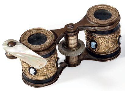 Une jumelle de théâtre en métal doré et patiné...