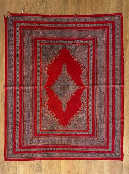 Tapis fond de laine rouge au médaillon central...