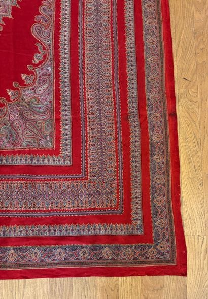 Tapis fond de laine rouge au médaillon central...