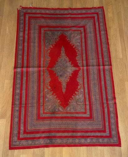 Tapis fond de laine rouge au médaillon central...