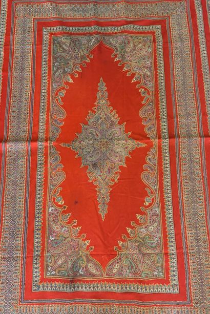 Tapis fond de laine rouge au médaillon central...
