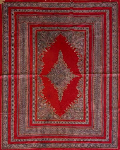 Tapis fond de laine rouge au médaillon central...