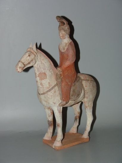 Cavalière à la coiffure en chignon sur sa...