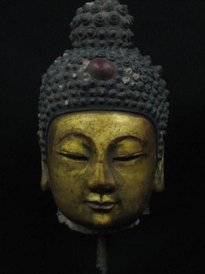 Tête de Bouddha. En stuc polychrome à rehauts...
