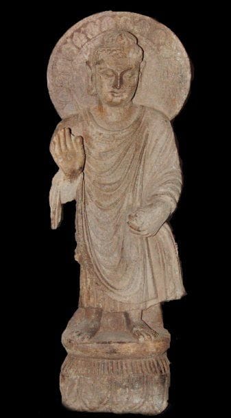 Bouddha auréolé, debout sur un socle, faisant...