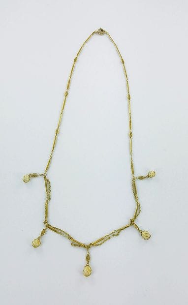Gold draped necklace set with five pearls...