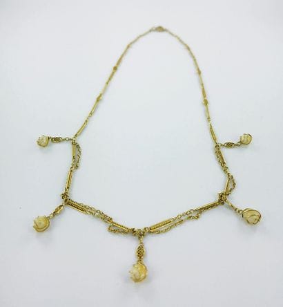 Gold draped necklace set with five pearls...