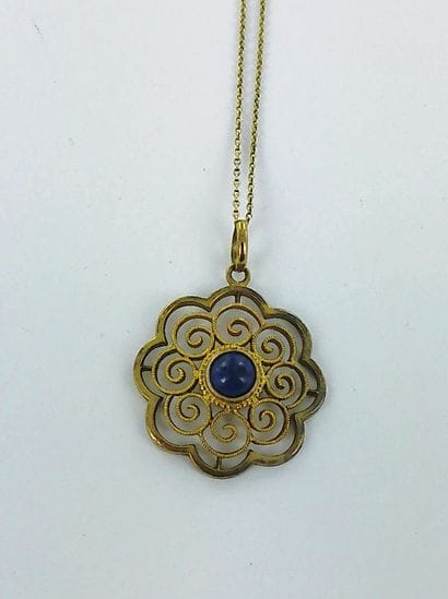 585-thousandths gold pendant set with a lapis...