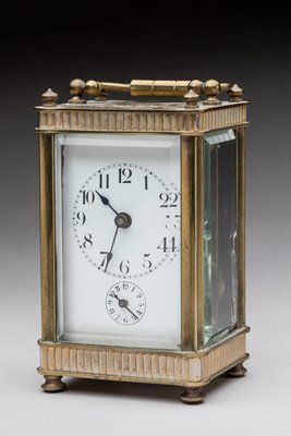 Travel alarm clock in brass and glass. 
19th...