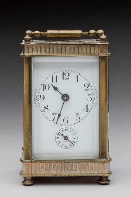 Travel alarm clock in brass and glass. 
19th...