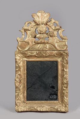 Mirror in a carved wood frame 
decorated...