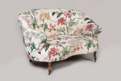 Sofa of corbeille form, front legs on casters,...