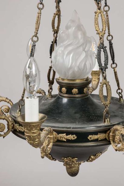 A brass and sheet metal chandelier with a...