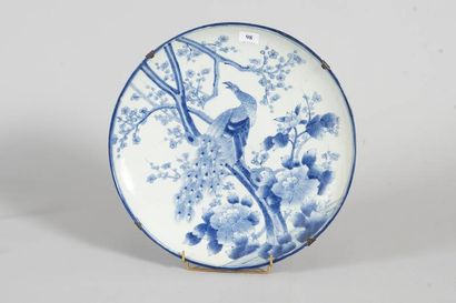 Plat rond en faïence à décor d'un paon sur...