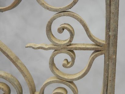 Grille en fer forgé à décor de volutes et...