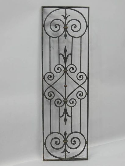 Grille en fer forgé à décor de volutes et...