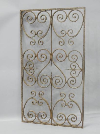 Grille en fer forgé à décor de volutes et...
