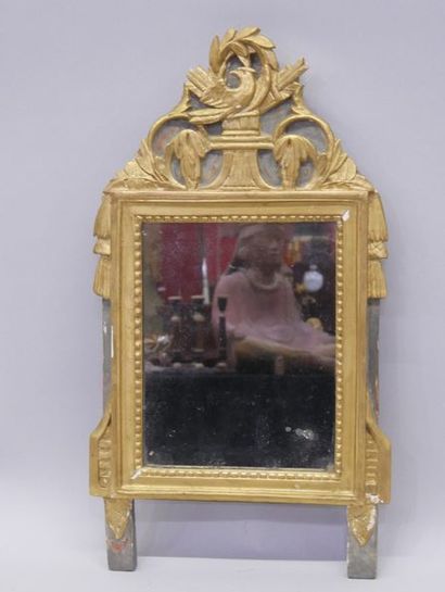 Dans un encadrement en bois doré, un miroir,...