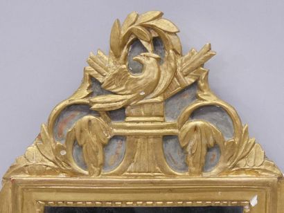 Dans un encadrement en bois doré, un miroir,...