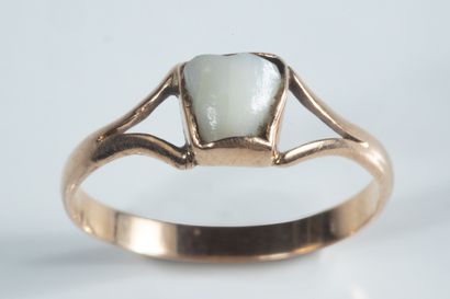 Small ring adorned with a milk tooth on yellow...