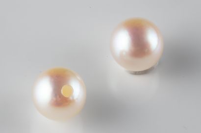 2 white cultured pearls with a piercing hole...