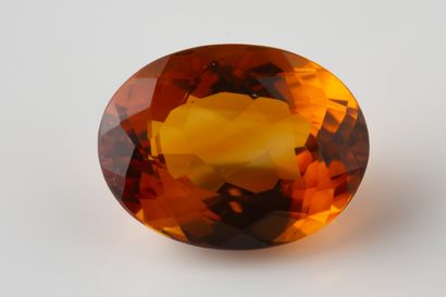 Oval faceted citrine on paper weighing approximately...