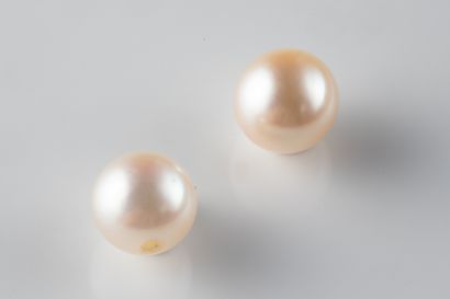 2 white cultured pearls with a piercing hole...