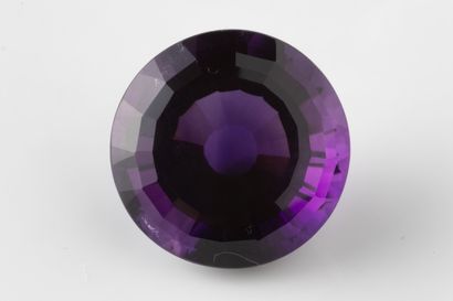 Round faceted amethyst on paper weighing...