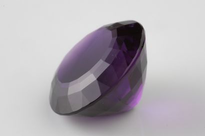Round faceted amethyst on paper weighing...