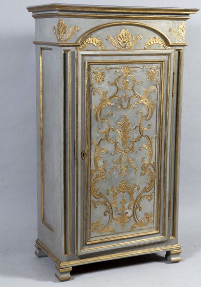 Small carved wood cupboard opening by a door,...