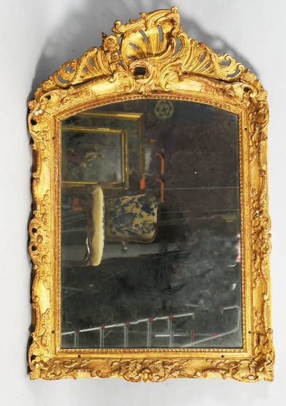 Miroir en bois sculpté et doré, le fronton...