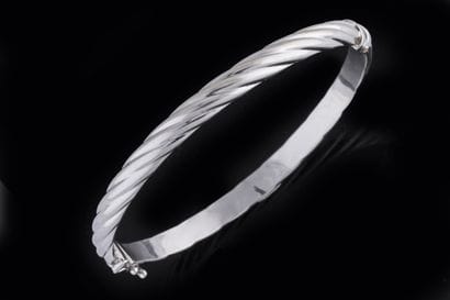 Bracelet jonc torsadé et ouvrant en or gris...