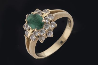 Daisy ring centered on a faceted oval emerald...