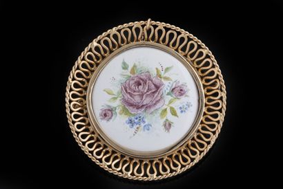 Round brooch centered on a porcelain floral...