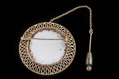 Round brooch centered on a porcelain floral...