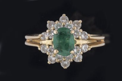 Daisy ring centered on a faceted oval emerald...