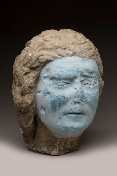 Carved limestone head; strands of hair falling...