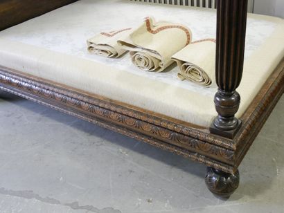 a single-headed canopy bed decorated with...