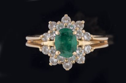 Bague marguerite centrée d’une émeraude ovale...