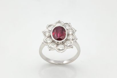 Bague marguerite centrée d’un rubis ovale...