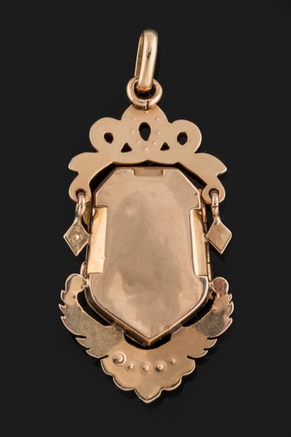 Souvenir pendant centered on an opening escutcheon...