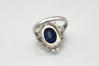 Bague marguerite centrée d’un saphir ovale...