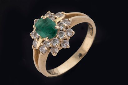 Bague marguerite centrée d’une émeraude ovale...