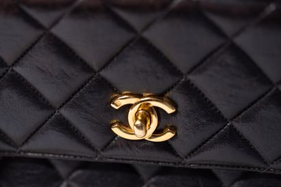 CHANEL
Sac en cuir matelassé noir avec bride...