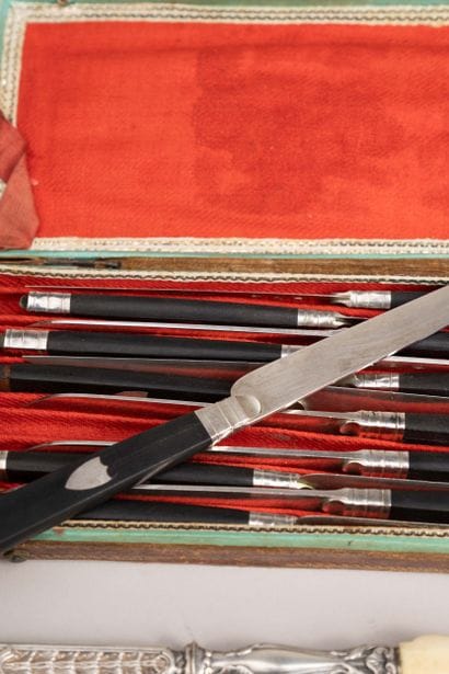 12 knives, silver blades, blackened wooden...