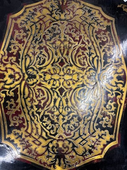 A scrolled-edge table made of blackened wood,...